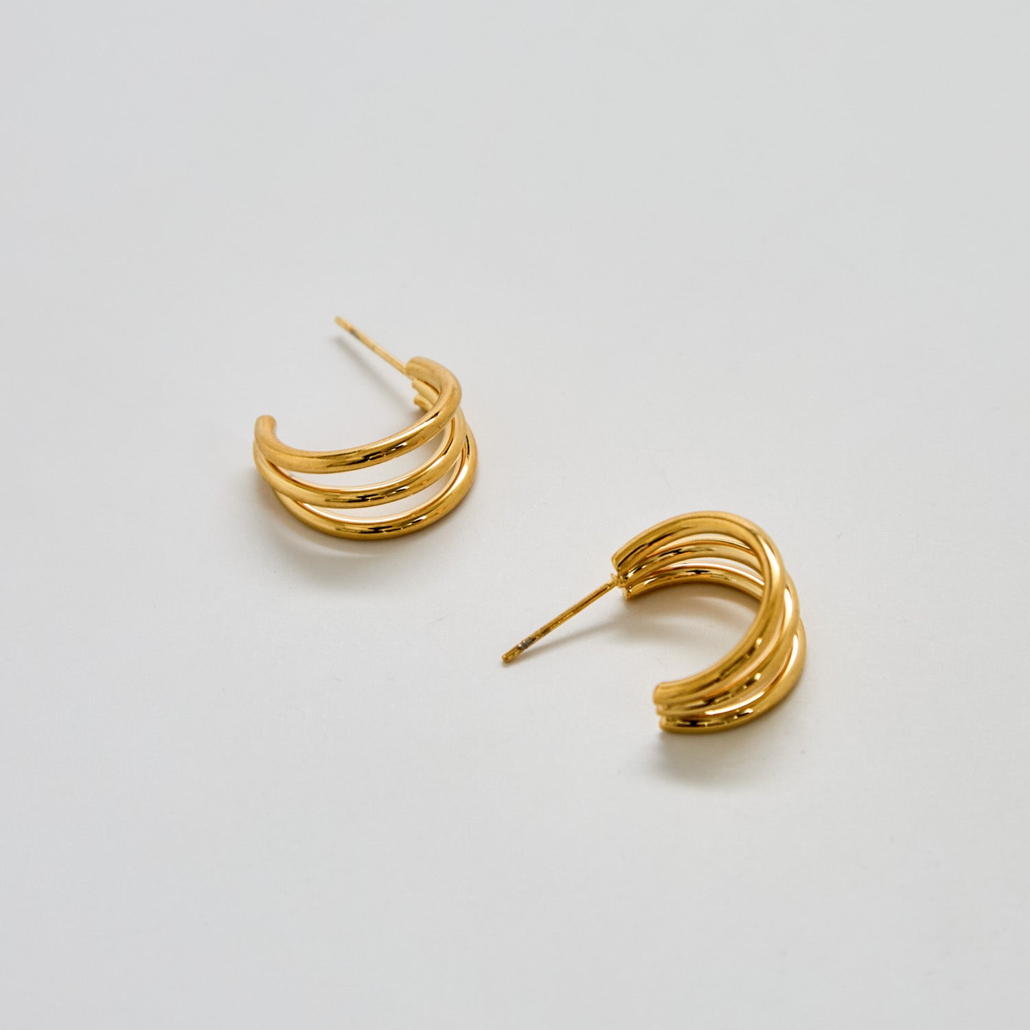 Pair of gold hoop earrings on a light gray background