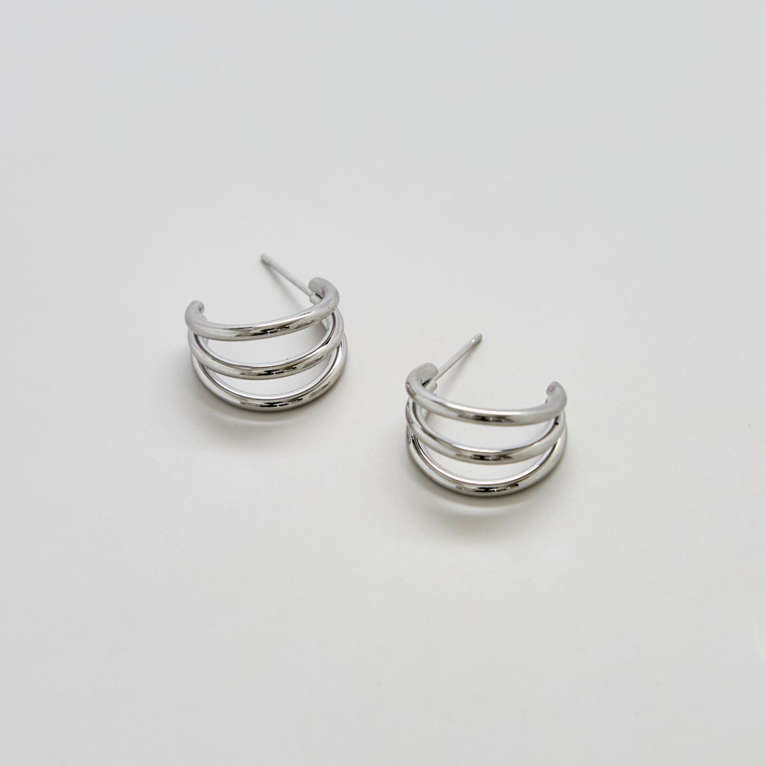 Pair of silver hoop earrings on a light gray background
