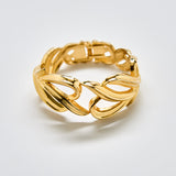 “Full view of vintage gold sculptural bracelet with wave-like link design and glossy gold finish