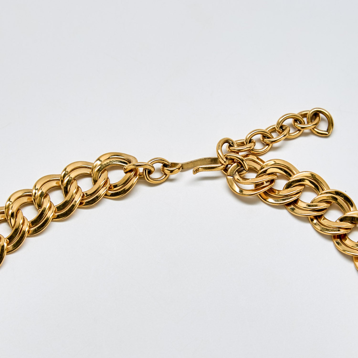 Detail of vintage Monet necklace clasp and extender chain in polished gold-tone metal.
