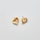 Angled view of vintage Monet gold heart earrings showing post back closure and dimensional open-heart shape.