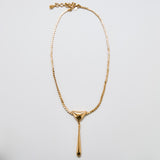 Full view of vintage Monet gold-tone pendant necklace with triangular and teardrop drop design, adjustable chain, and signed clasp.