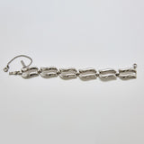 Front view of vintage Monet silver-tone bracelet featuring sculptural wave-style links and safety chain clasp.