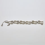 Back view of vintage Monet silver-tone wave link bracelet showing clasp detail and polished curved link design.