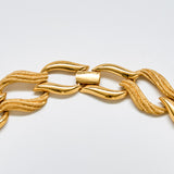 Detail of vintage Napier gold necklace clasp and smooth sculptural links with fine mesh texture.