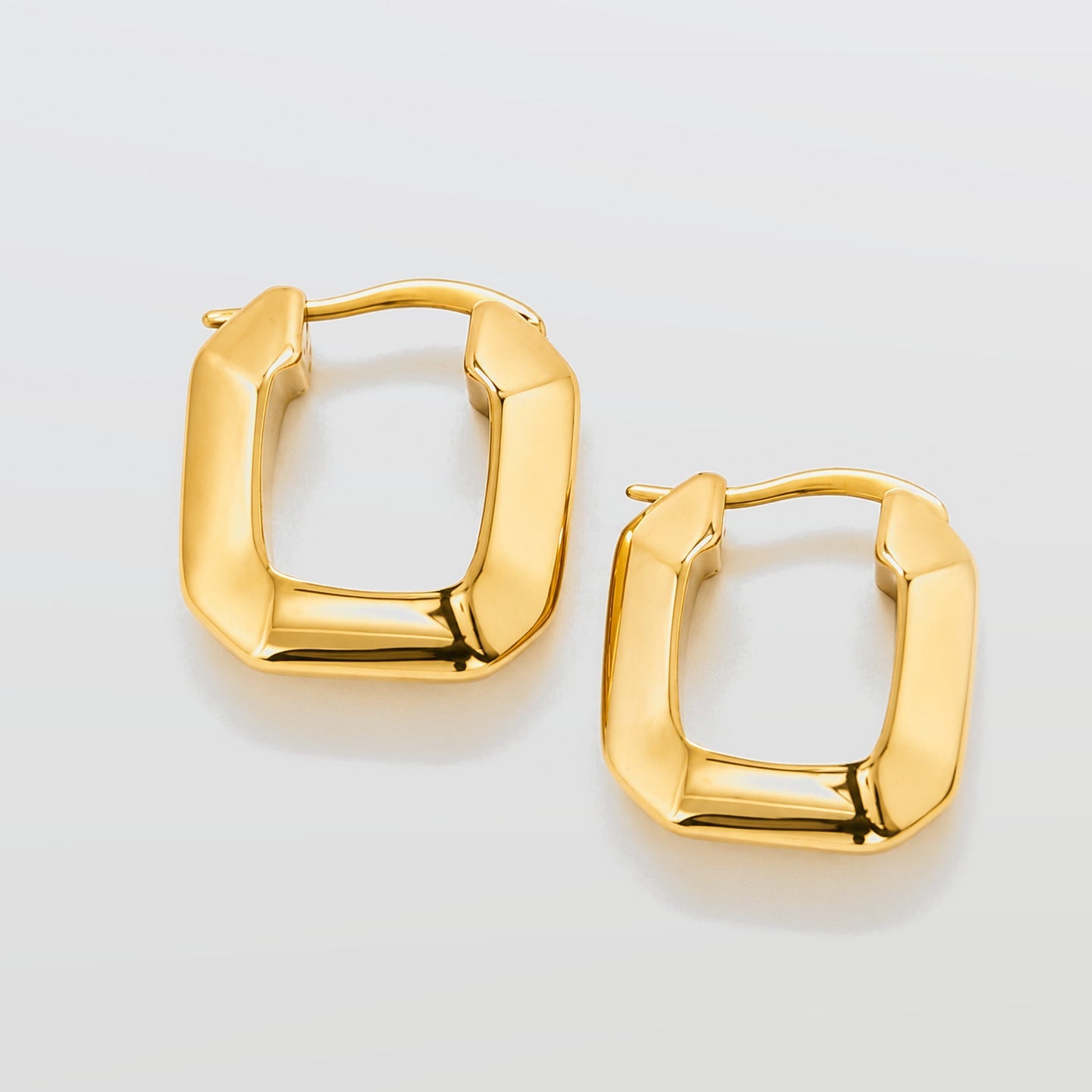 Gold hoop earrings on a light gray background