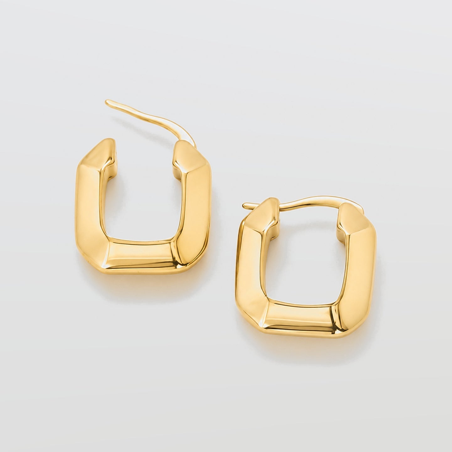 Gold hoop earrings on a light gray background