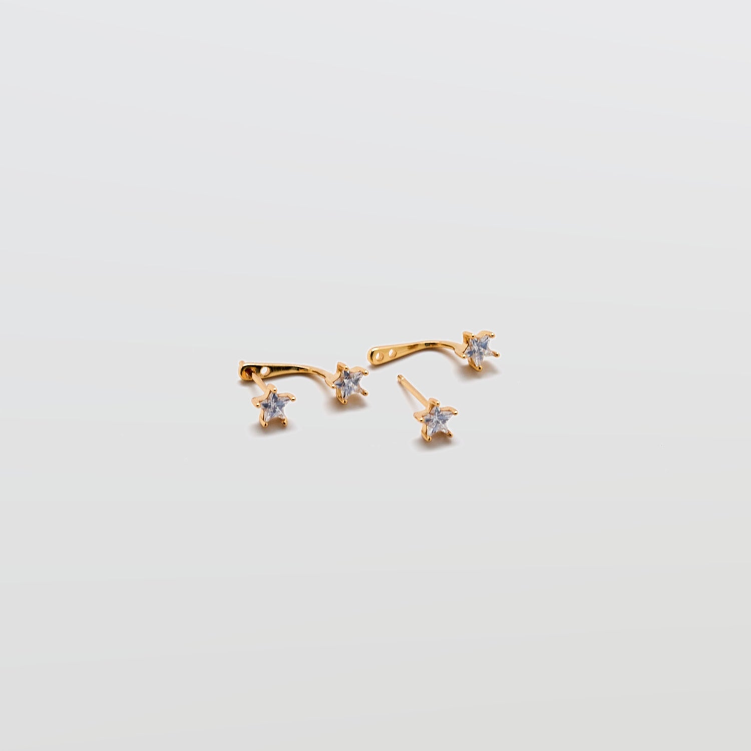 Gold Double CZ Stud Ear Jacket Earrings with cubic zirconia studs and curved ear jacket backing on white background.