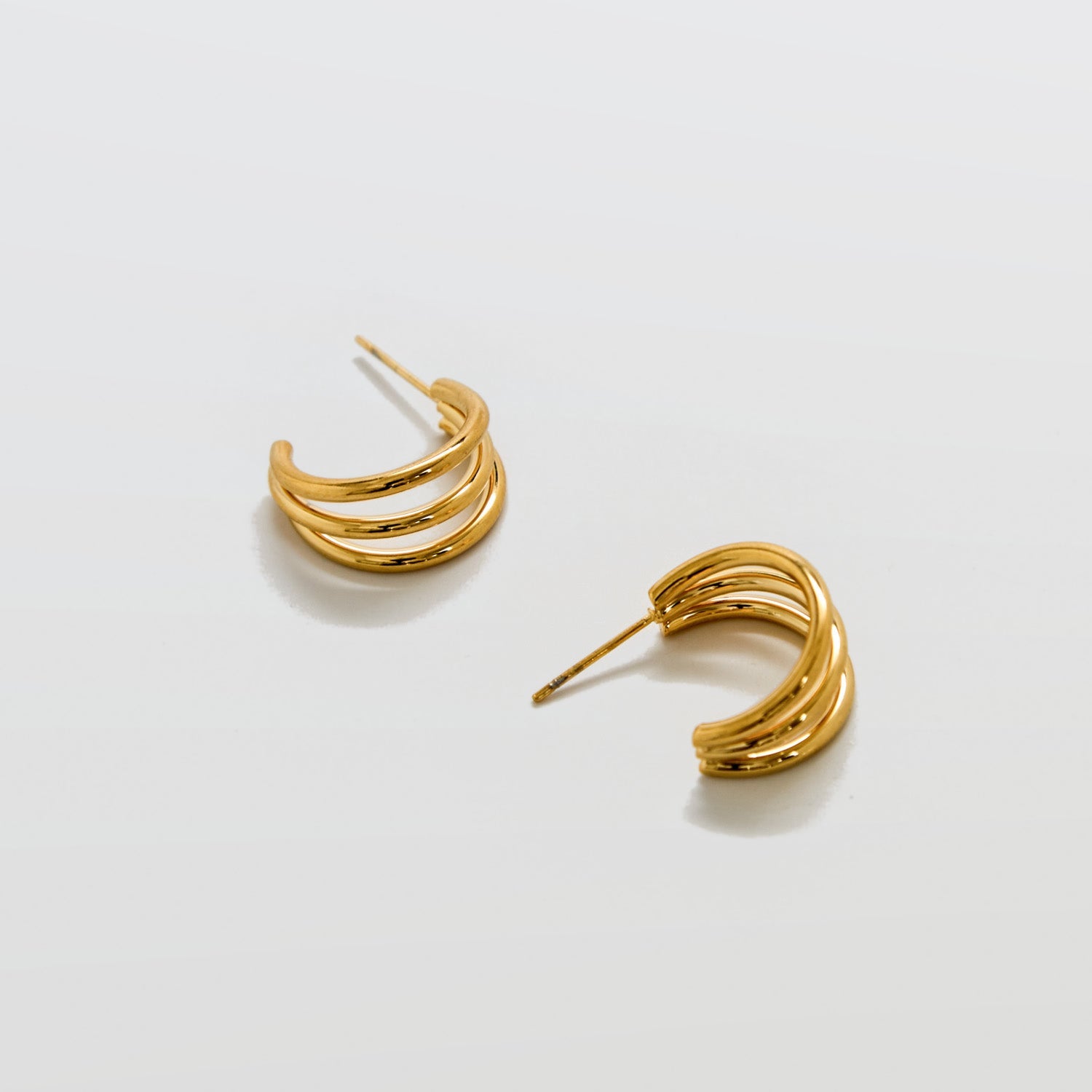 Pair of gold hoop earrings on a light gray background