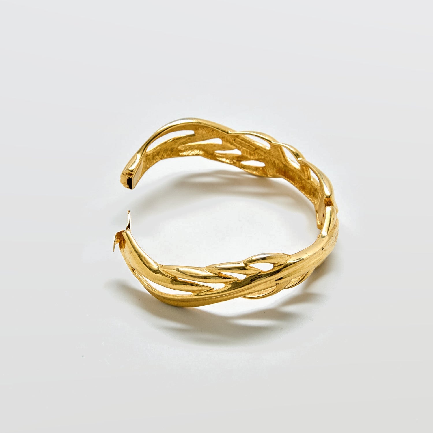 Gold bracelet on a light gray background