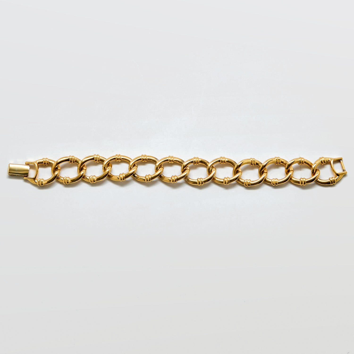 Gold chain bracelet on a light gray background