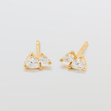 Gold earrings with clear gemstones on a light gray background