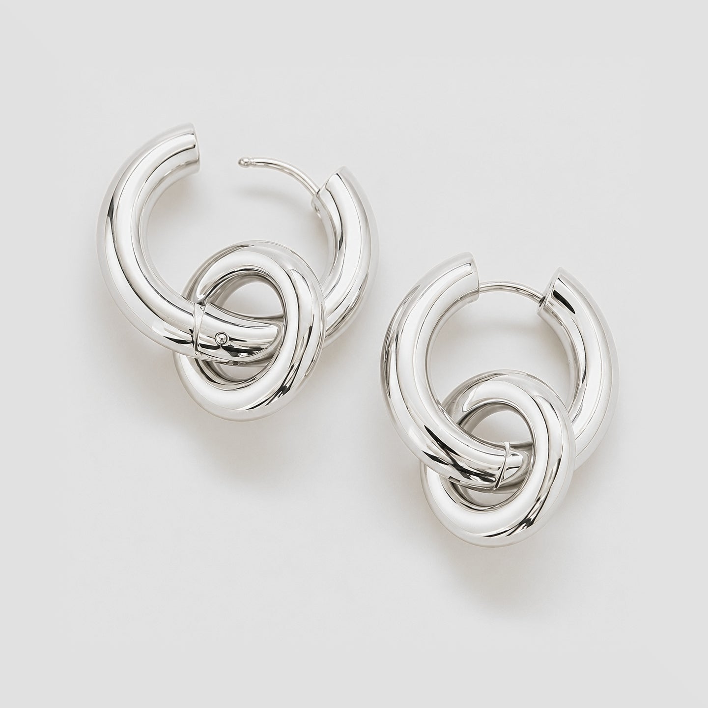 Pair of silver hoop earrings on a light gray background