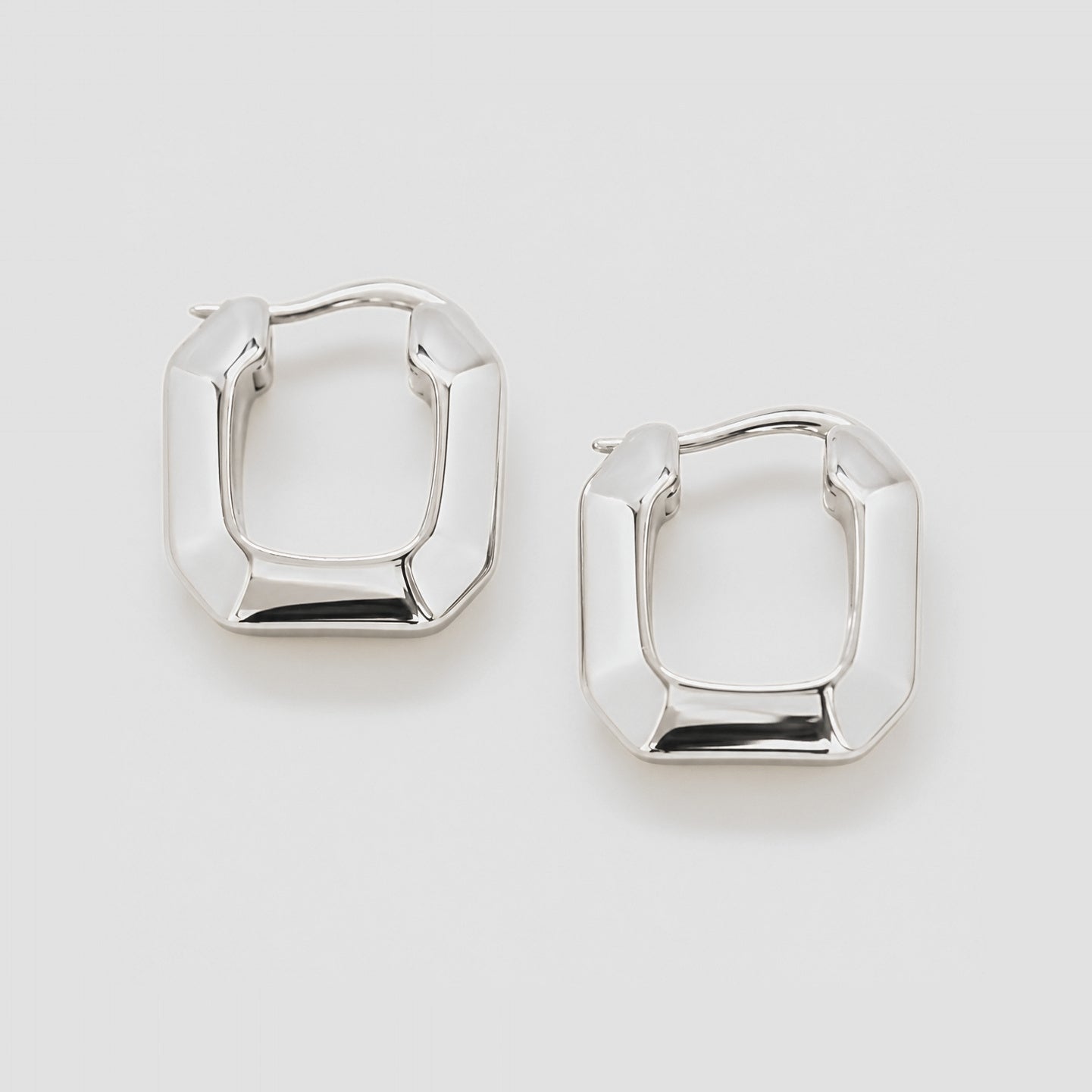 Pair of silver hoop earrings on a light gray background