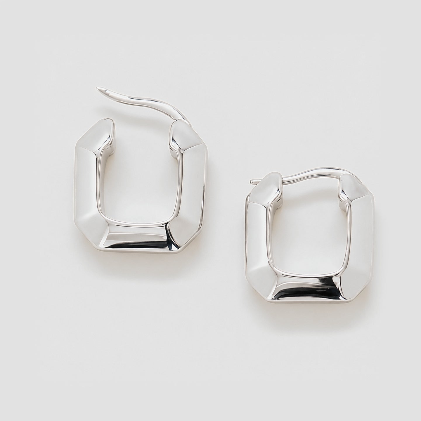 Pair of silver hoop earrings on a light gray background