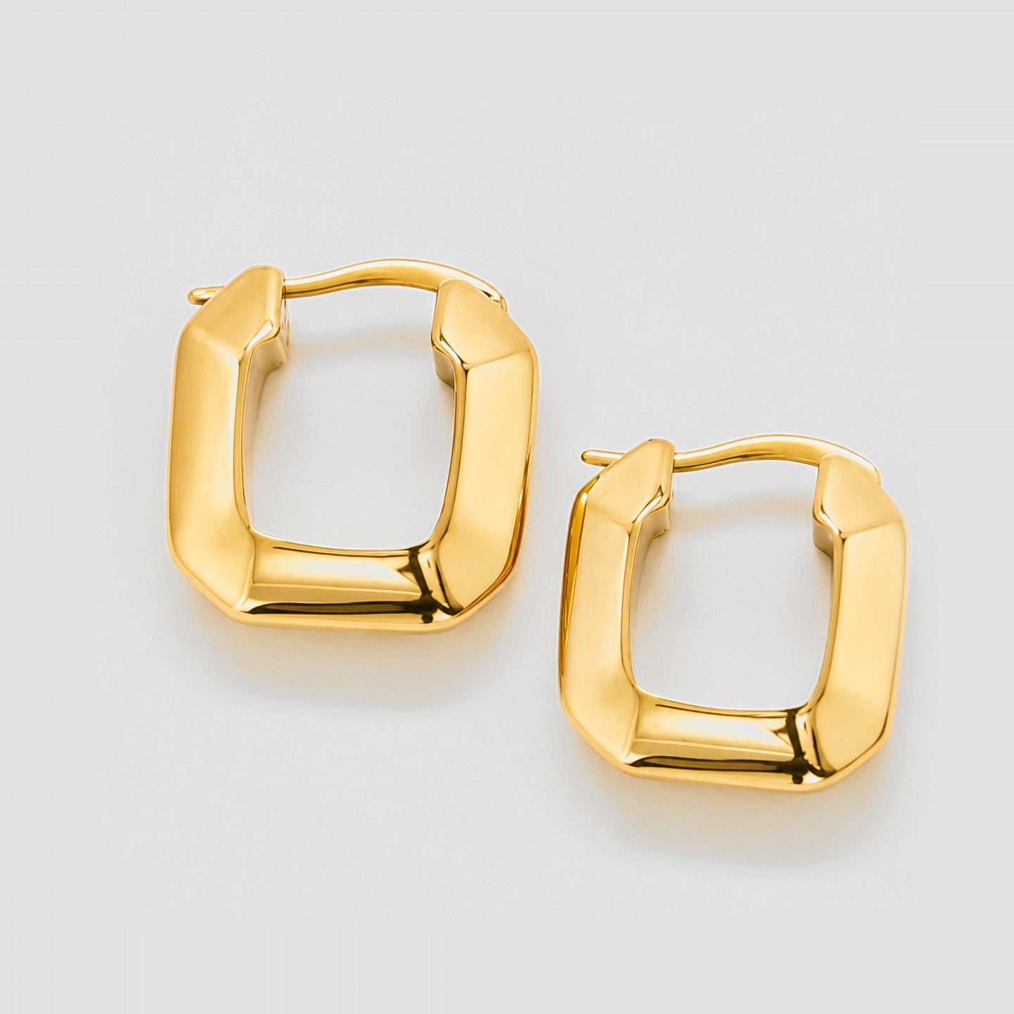 Gold hoop earrings on a light gray background