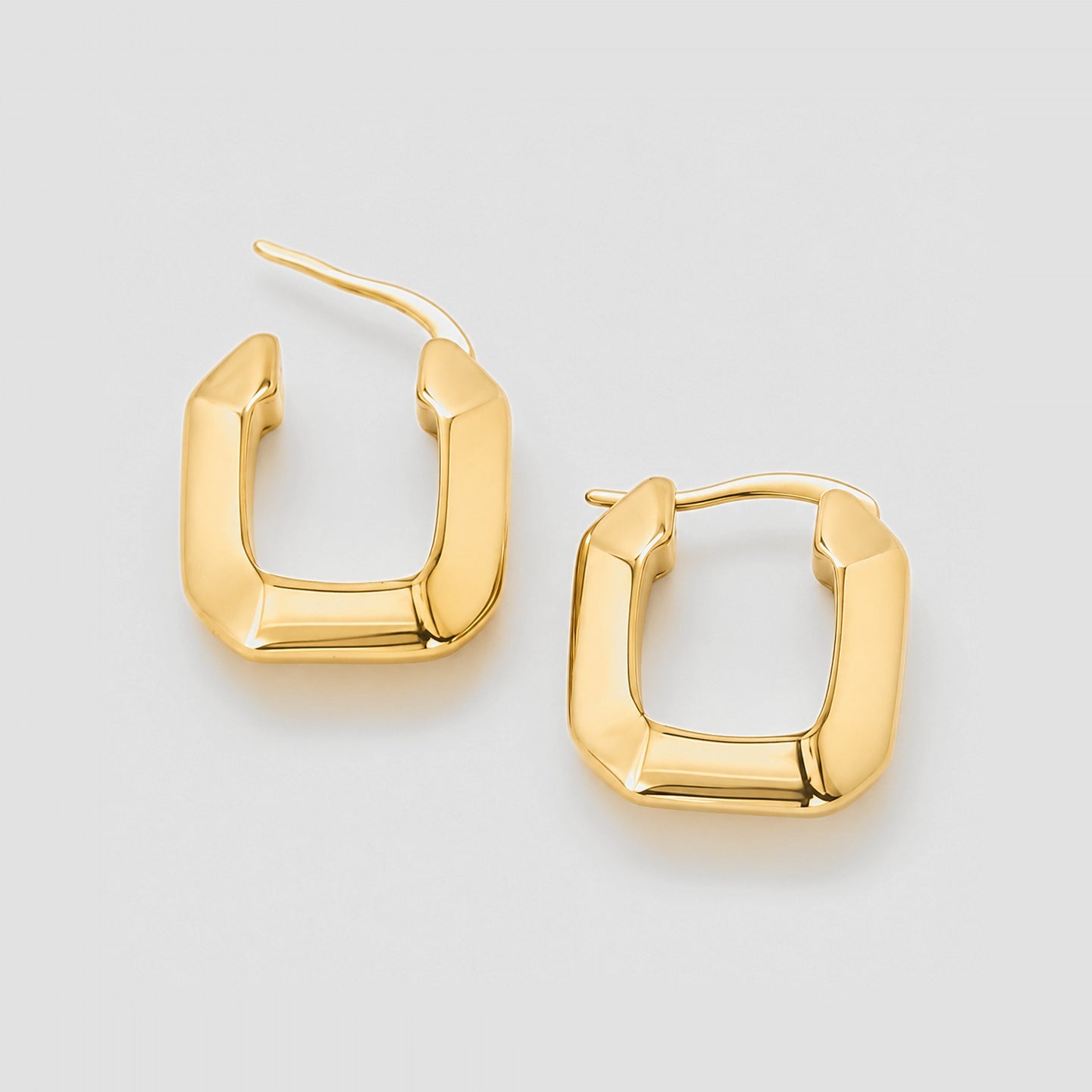 Gold hoop earrings on a light gray background