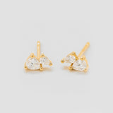 Gold earrings with clear gemstones on a light gray background