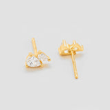 Gold heart-shaped earrings on a light gray background