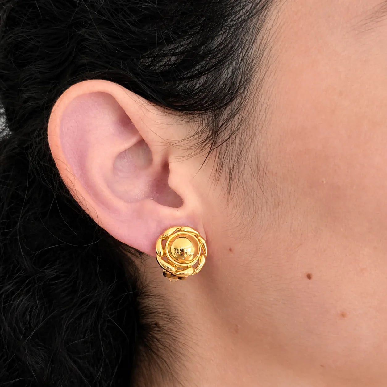 Model wearing Vintage Anne Klein gold-tone lion medallion clip-on earring, close-up