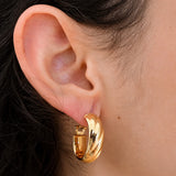 Model wearing Vintage Monet gold-tone twist hoop earring, close-up