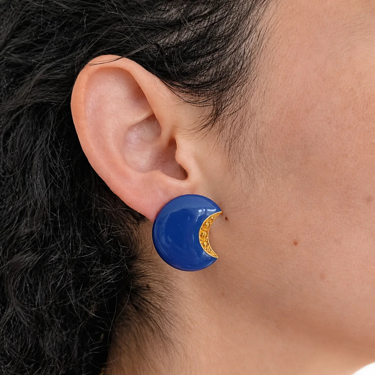 Model wearing Vintage cobalt blue crescent clip-on earring, close-up
