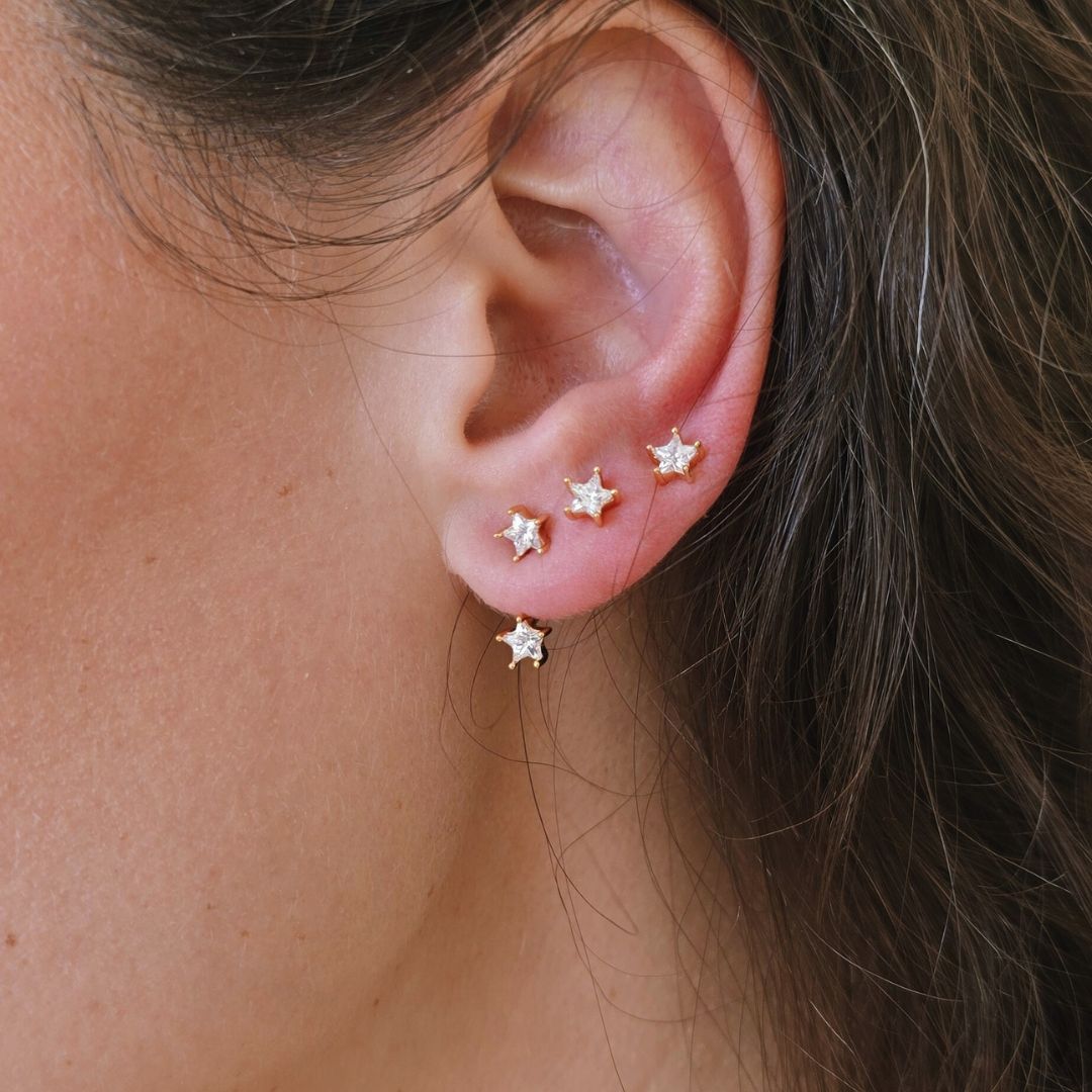 Gold Double CZ Stud Ear Jacket Earrings worn on ear with star stud stacked with multiple piercings.
