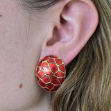 Close-up of a red patterned earring worn by a person.