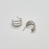 Pair of silver hoop earrings on a light gray background