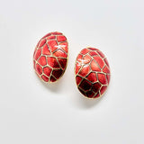 Red patterned earrings on a light gray background