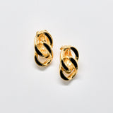 Gold hoop earrings with black accents on a light gray background