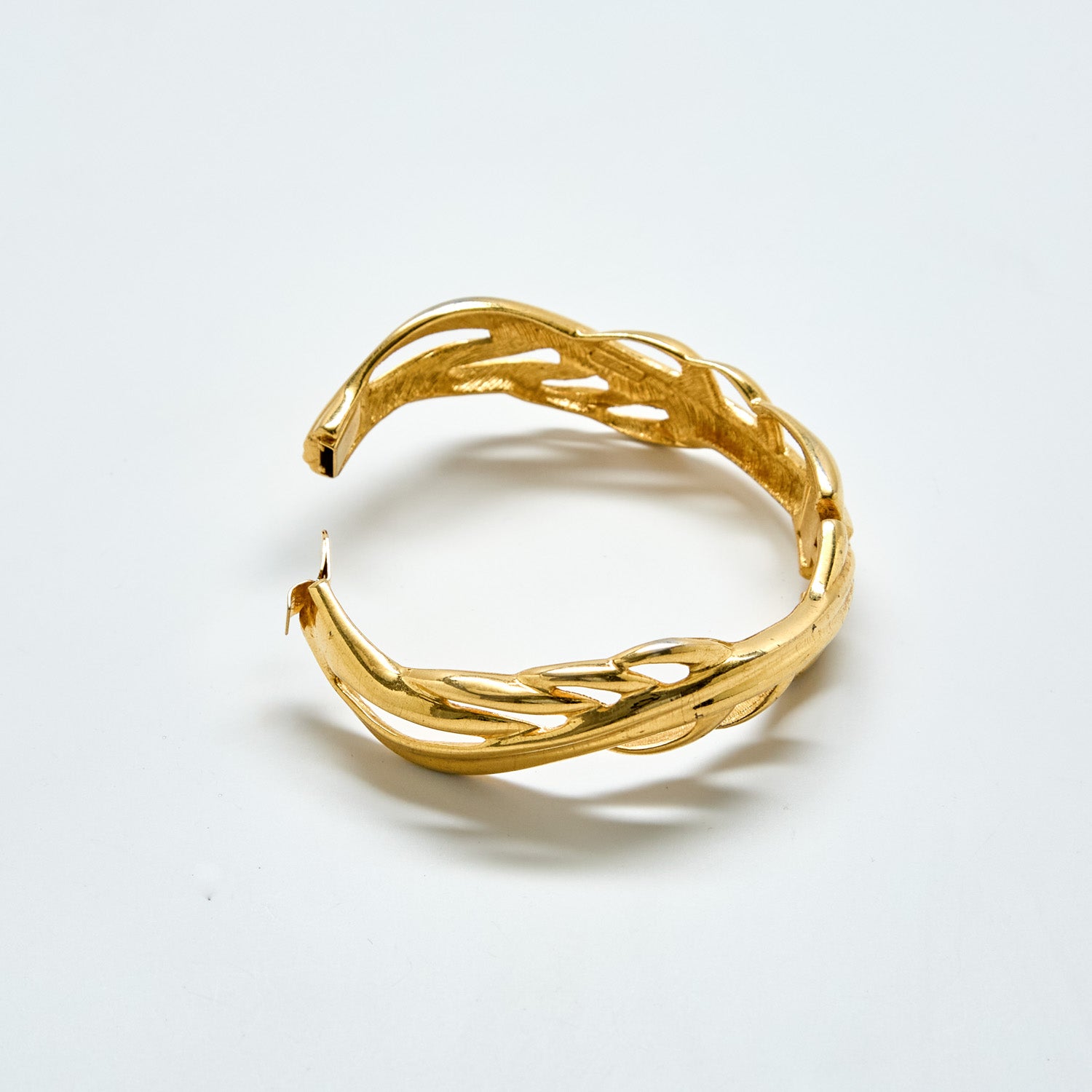 Gold bracelet on a light gray background
