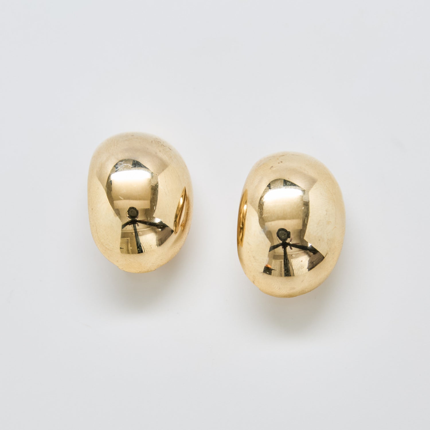 Front view of vintage gold-tone dome clip-on earrings with high-polish finish and rounded sculptural design.