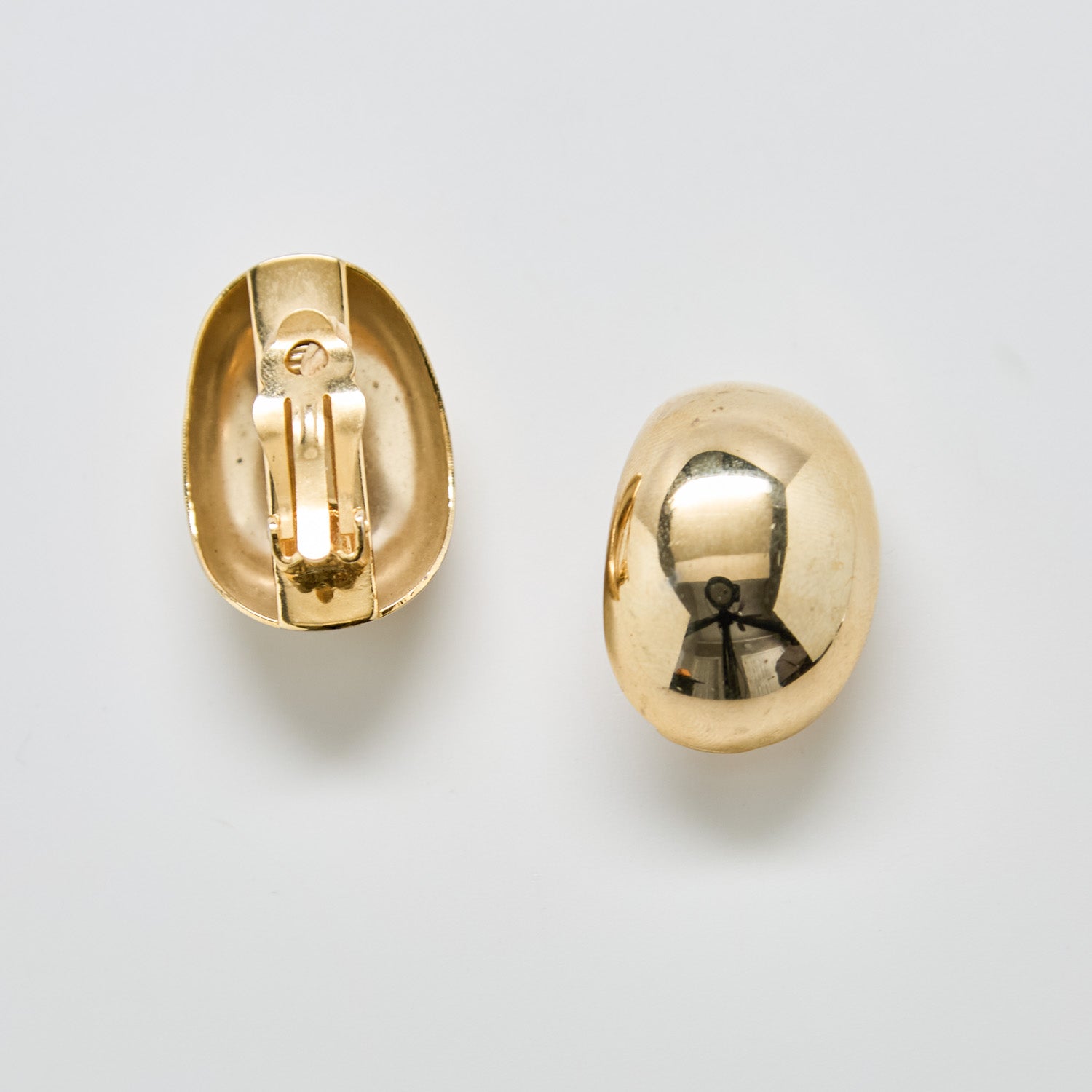 Back view of vintage gold dome earrings showing clip-on closure and smooth interior design.