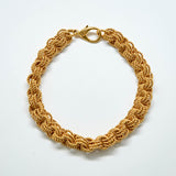 Gold braided bracelet on a white background