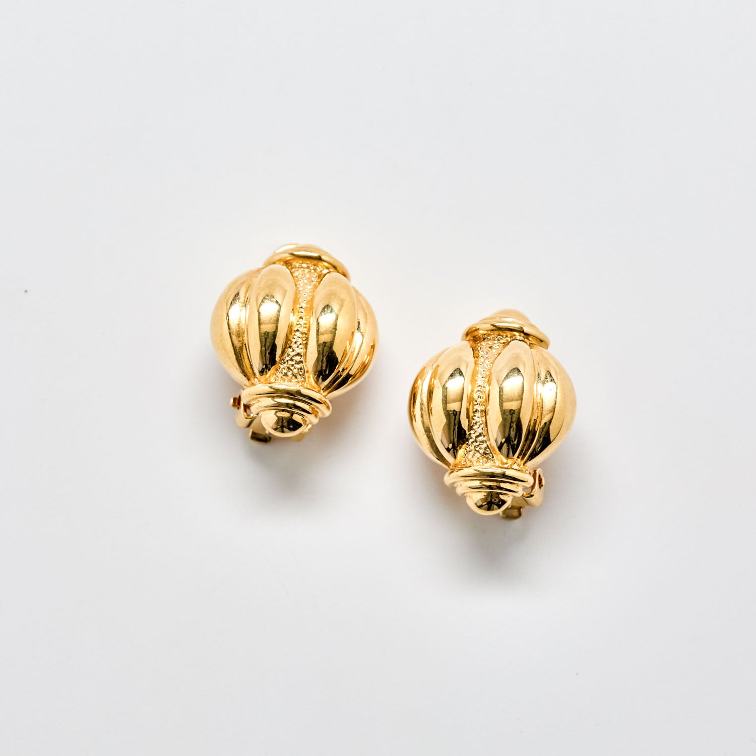 Pair of gold earrings on a light gray background