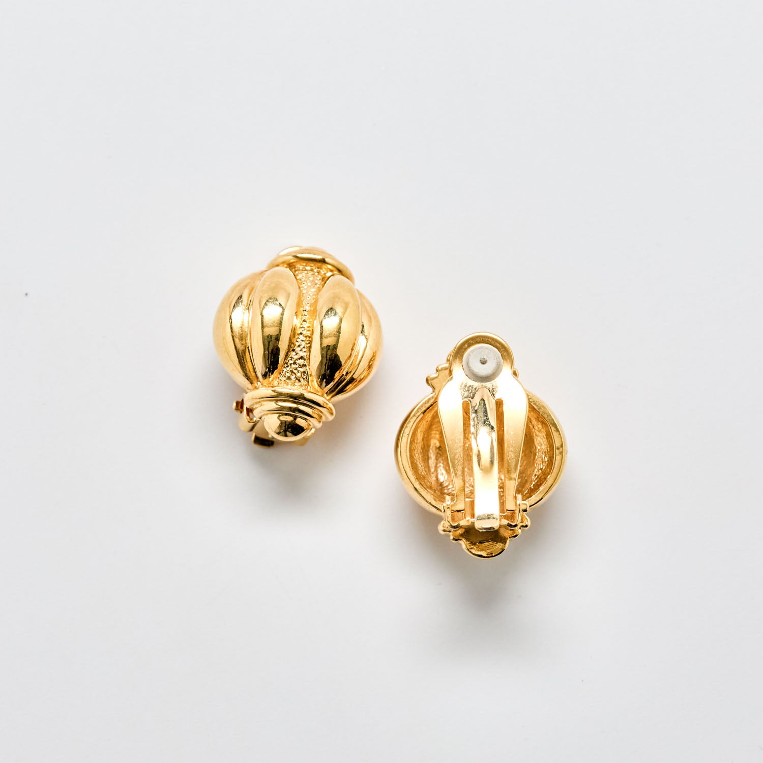 Pair of gold earrings on a light gray background