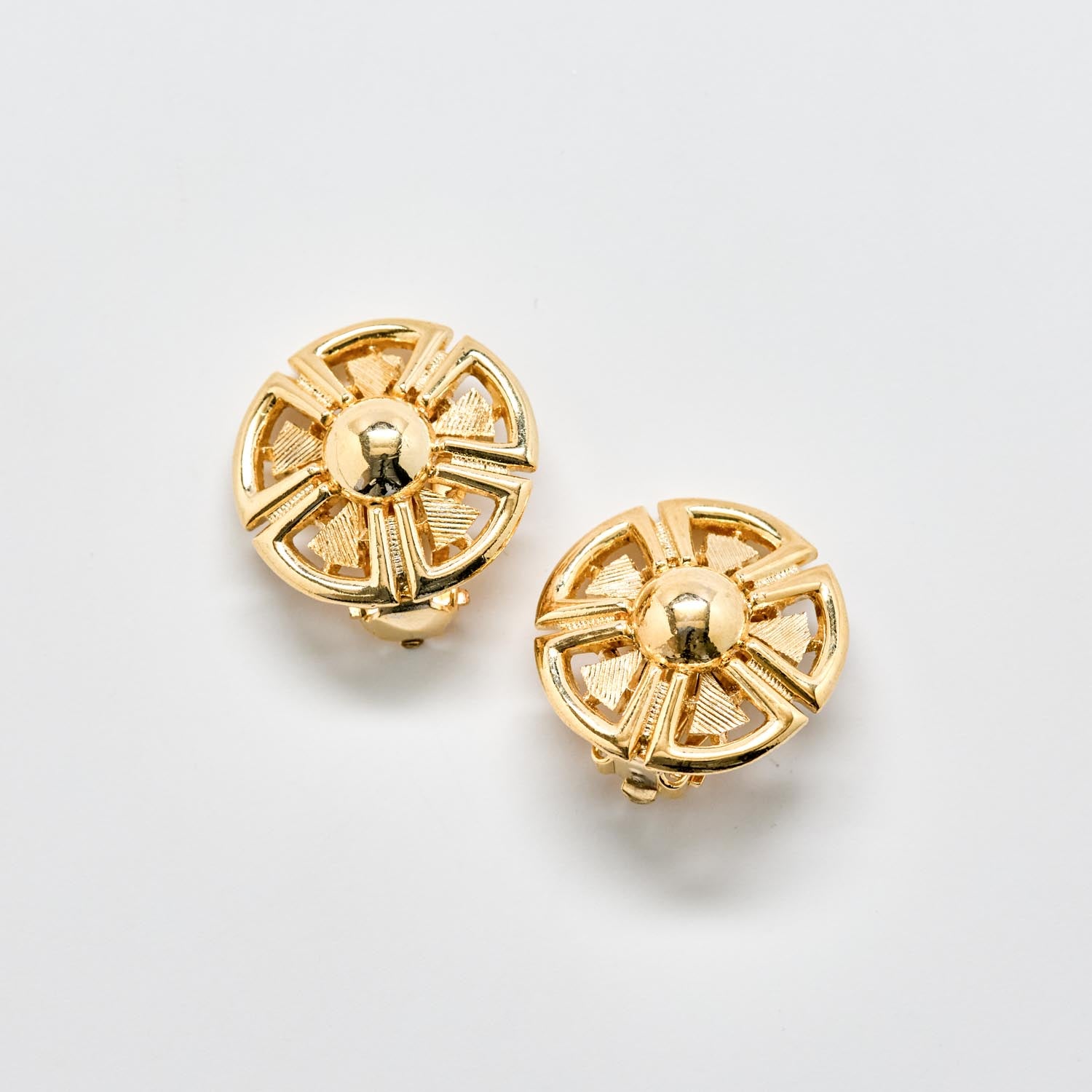 Pair of gold earrings on a light gray background