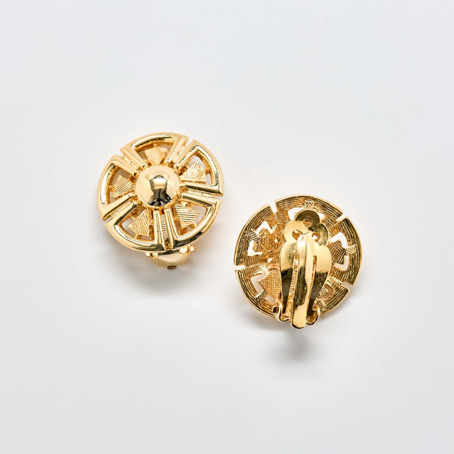 Pair of gold earrings on a light gray background