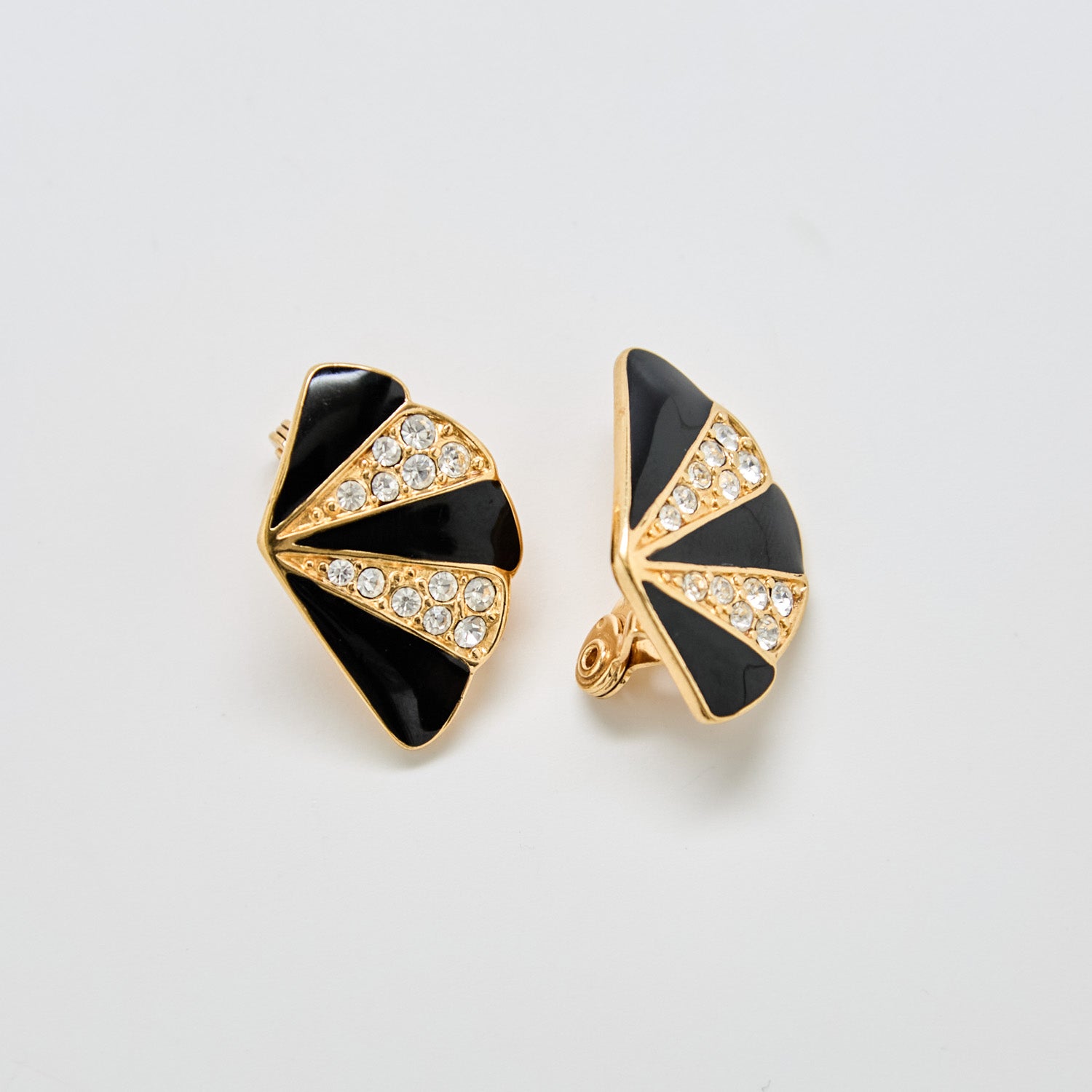 Front view of vintage Monet gold-tone fan earrings with black enamel panels and crystal rhinestone accents.