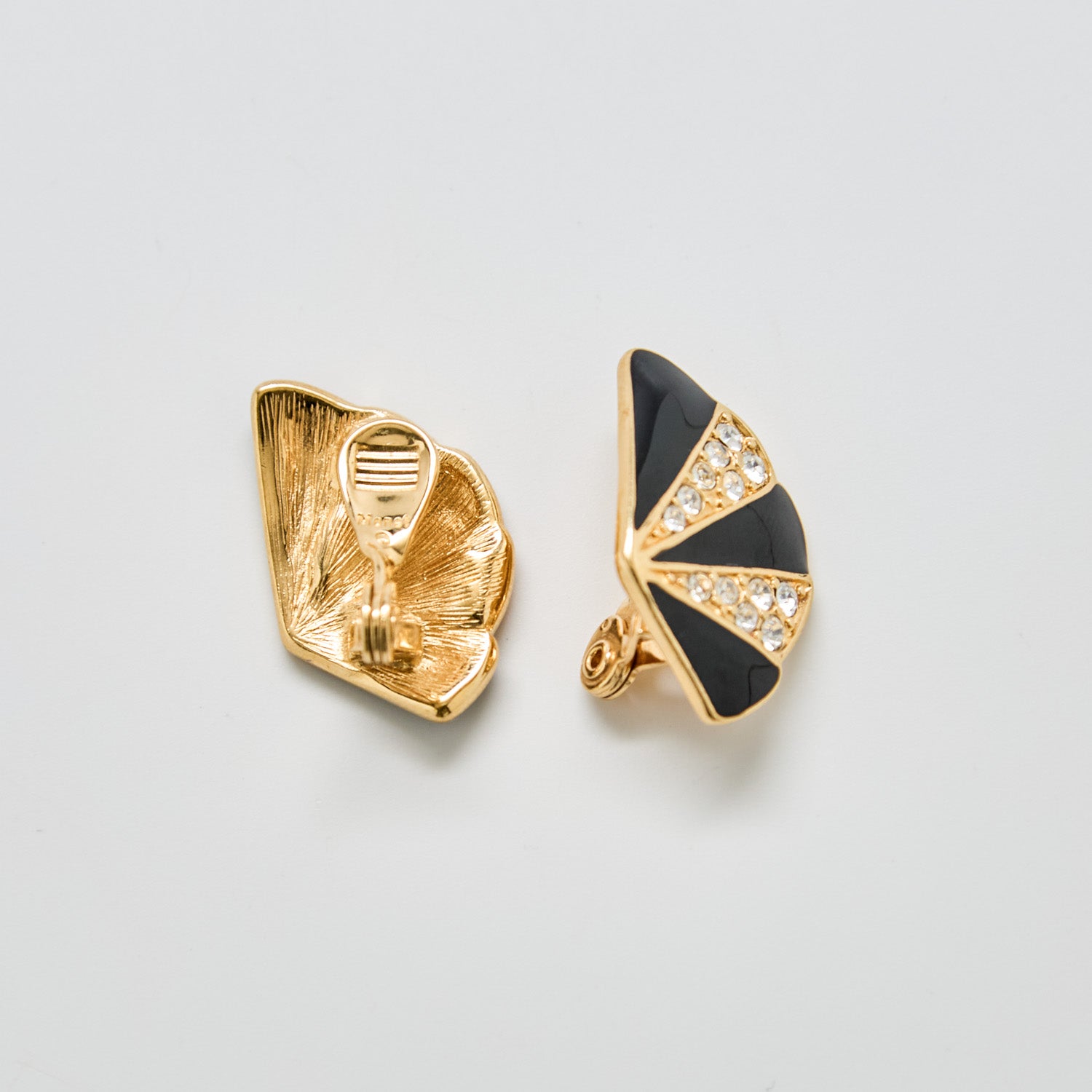 Back view of vintage Monet black and gold fan clip-on earrings showing Monet signature and clip closure.