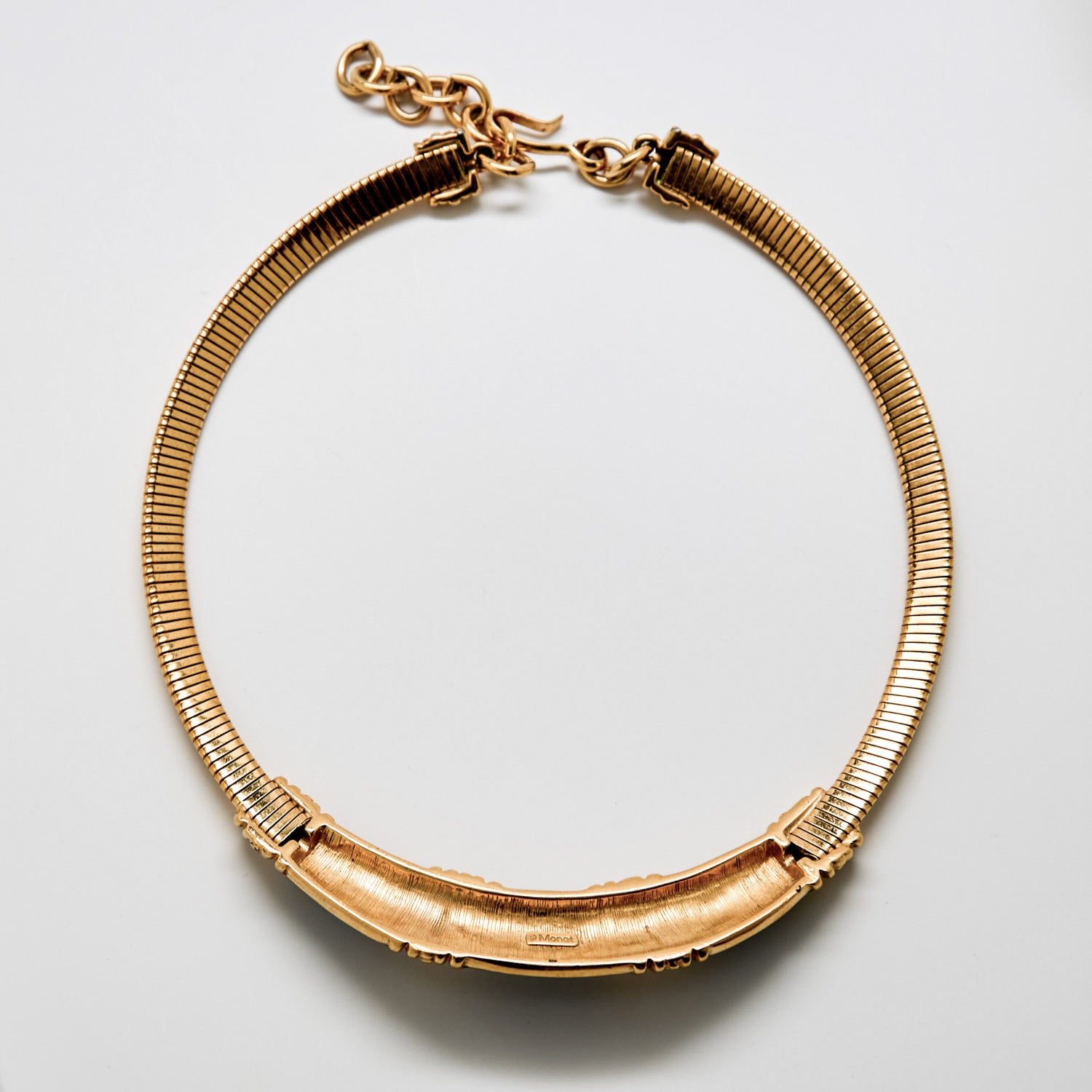 Gold bracelet on a light gray background