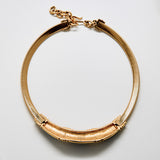 Gold bracelet on a light gray background