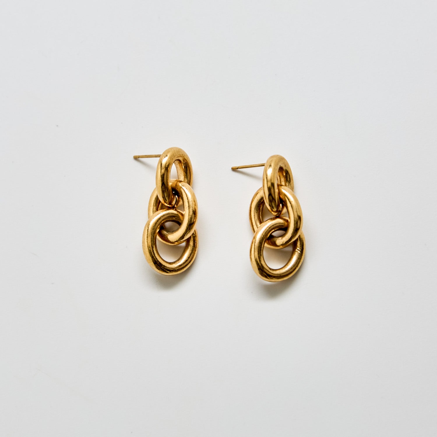 Front view of vintage Monet gold-tone chain link drop earrings featuring interlocking circular links and polished finish.