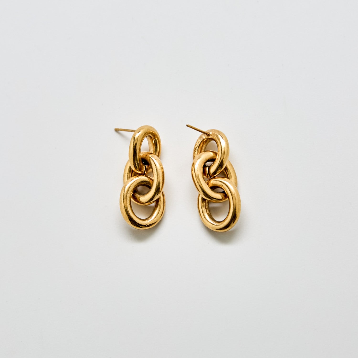 Angled view of vintage Monet gold chain link earrings showing dimensional link design and post back closure.
