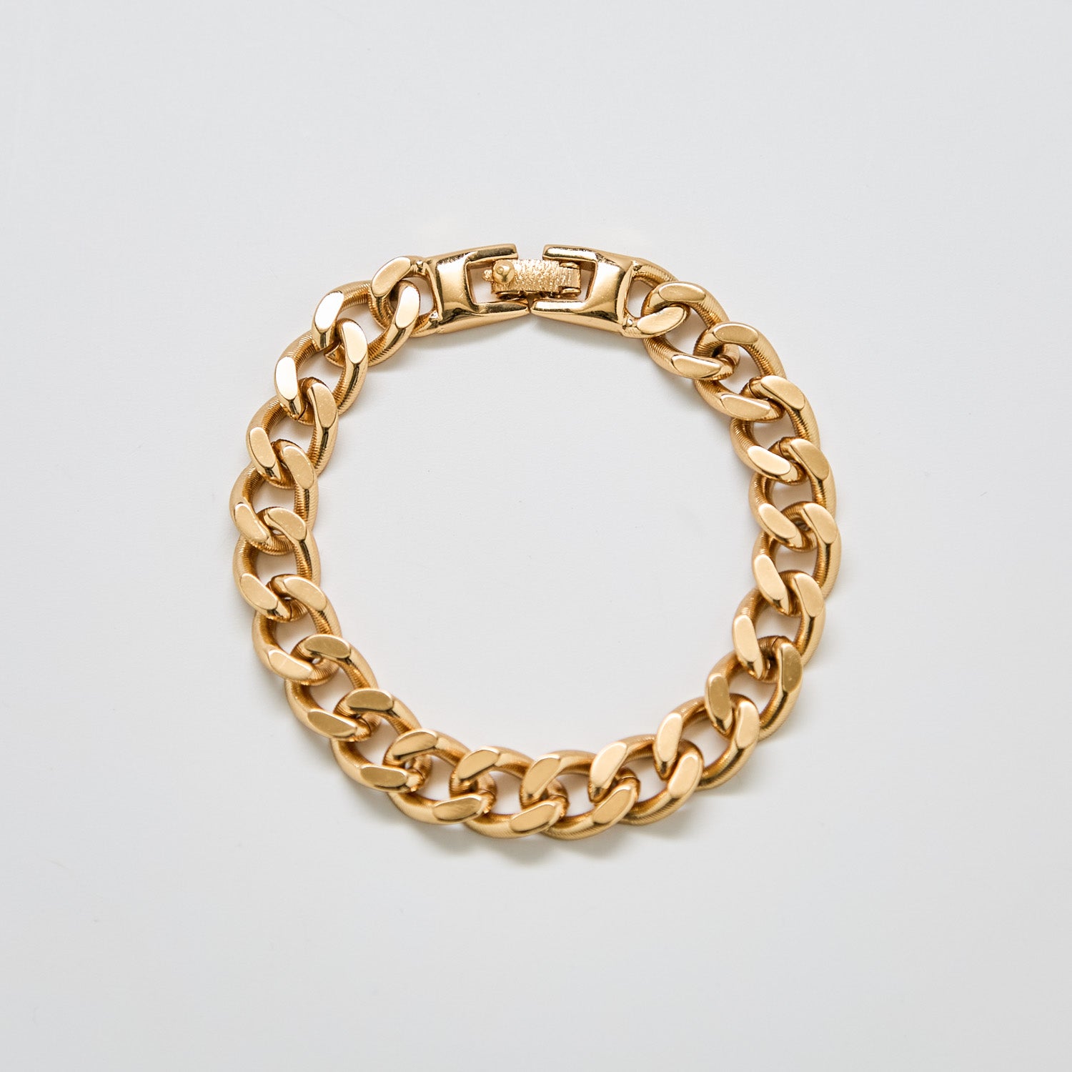 Full view of vintage Monet gold-tone chain bracelet featuring bold curb-style links and fold-over clasp.