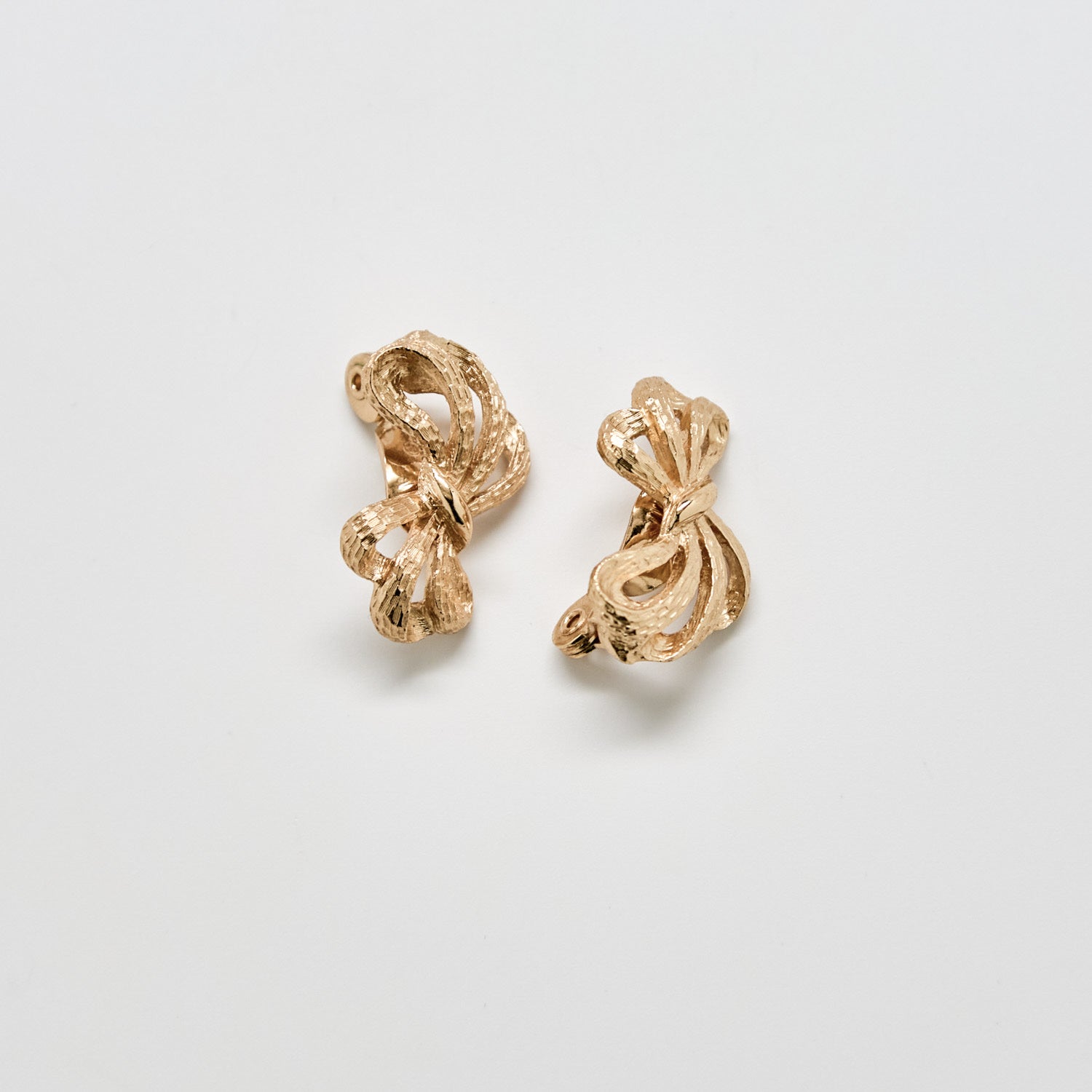 Pair of gold earrings on a light gray background