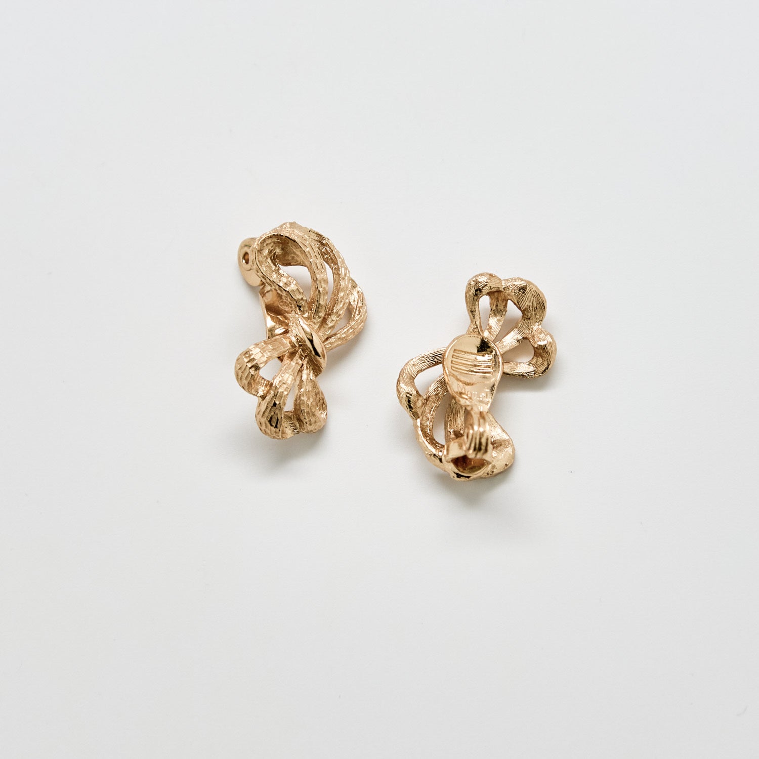 Pair of gold earrings on a light gray background