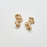 Pair of gold earrings on a light gray background