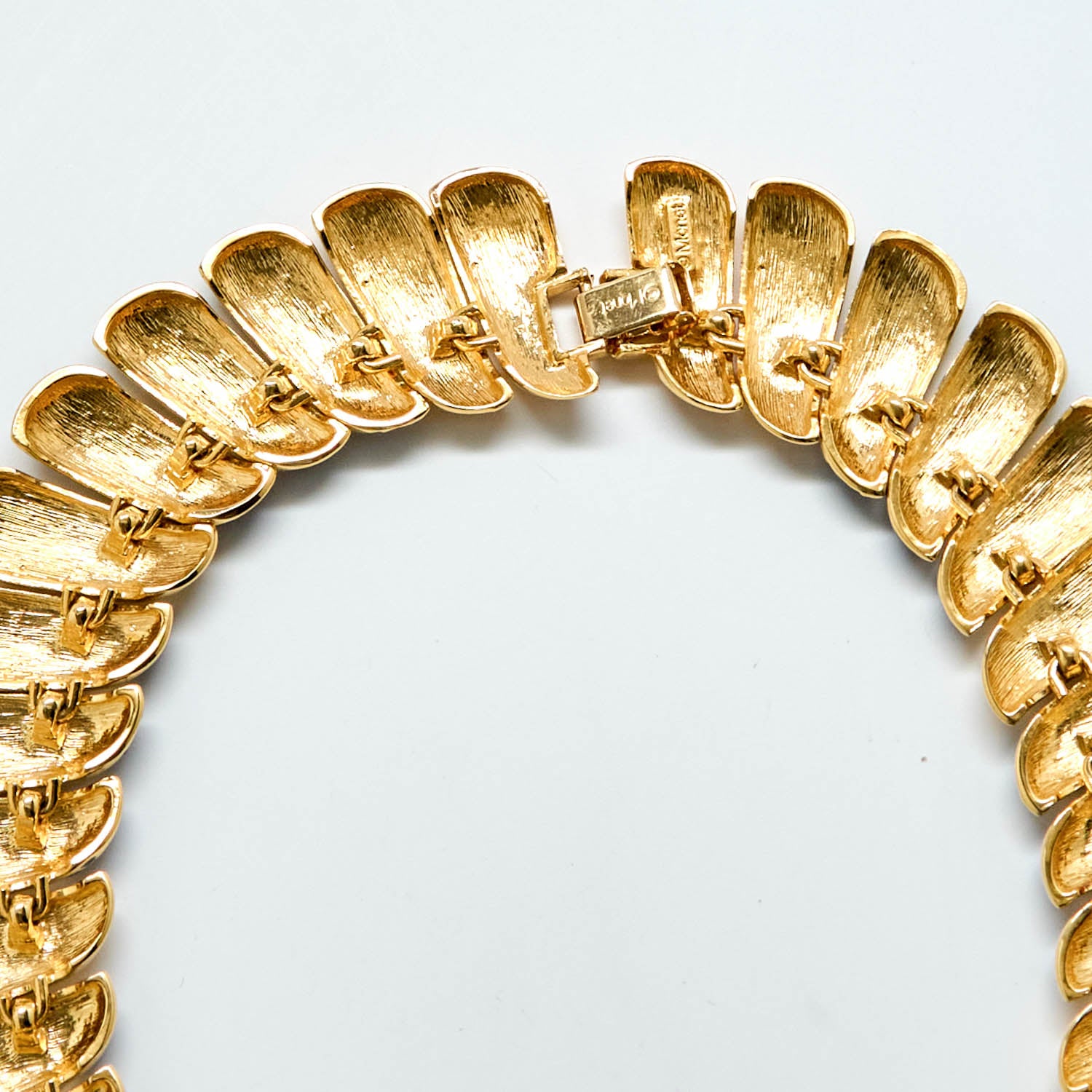 Back of Gold necklace on a light gray background